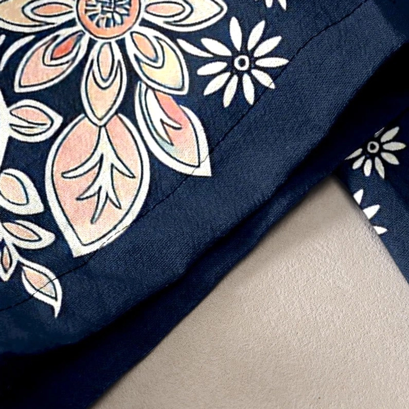 Detailed lotus and paisley floral pattern on navy cotton harem pants with pastel pink and white accents