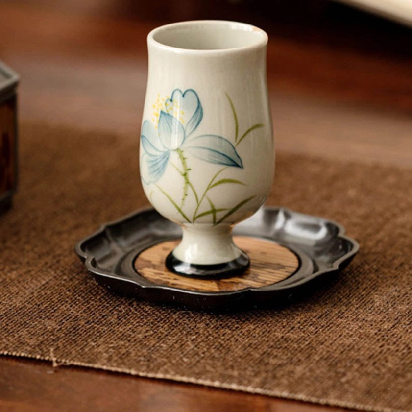 Hand-painted lotus flower pattern on ceramic tea cup showing traditional Buddhist artistic technique and matte finish
