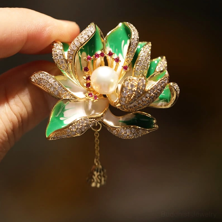 Green enamel lotus brooch with central pearl and red gemstone stamens, side view close-up