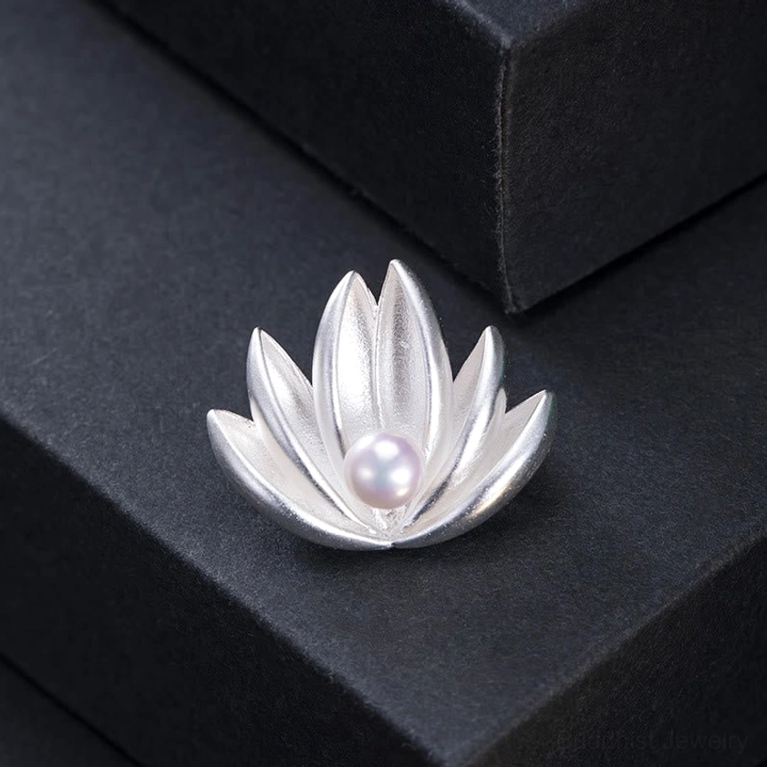 Handmade lotus brooch with pearl centered stone displayed on black gift box showing compact floral silver design