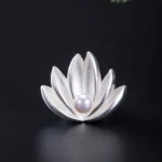 925 sterling silver lotus flower pearl brooch front view flat lay with matte silver petals and central freshwater pearl on black background
