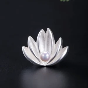 925 sterling silver lotus flower pearl brooch front view flat lay with matte silver petals and central freshwater pearl on black background