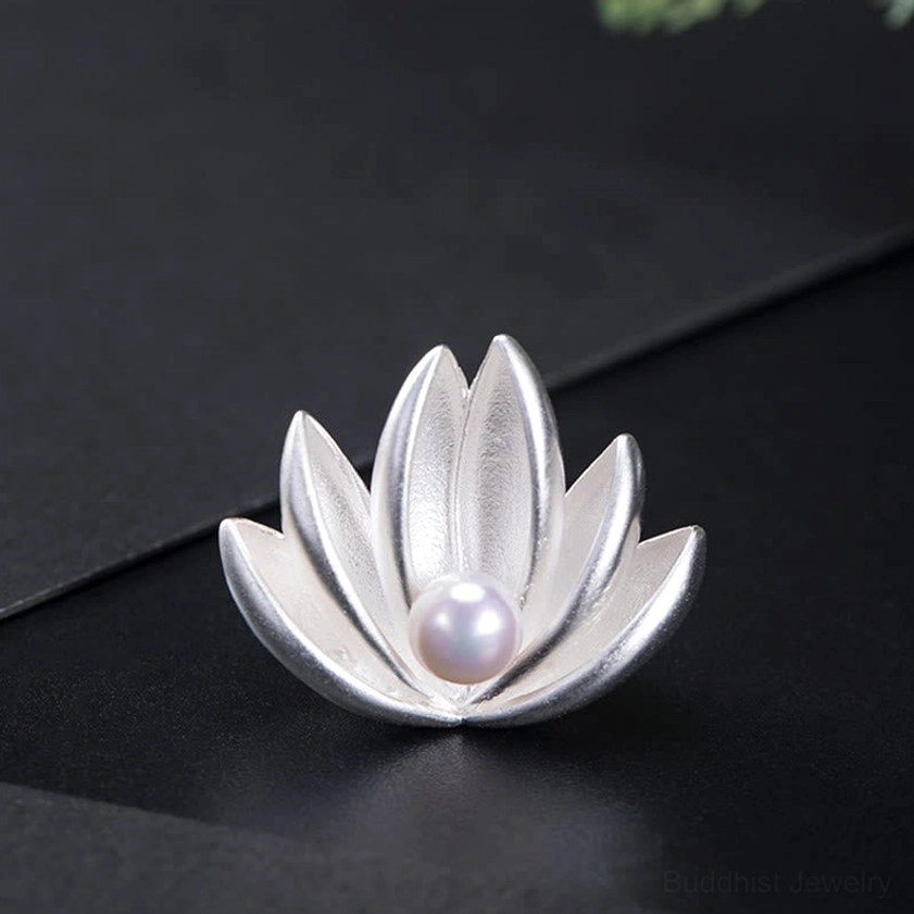 Three-quarter view of sterling silver lotus brooch showing symmetric layered petals with white freshwater pearl center