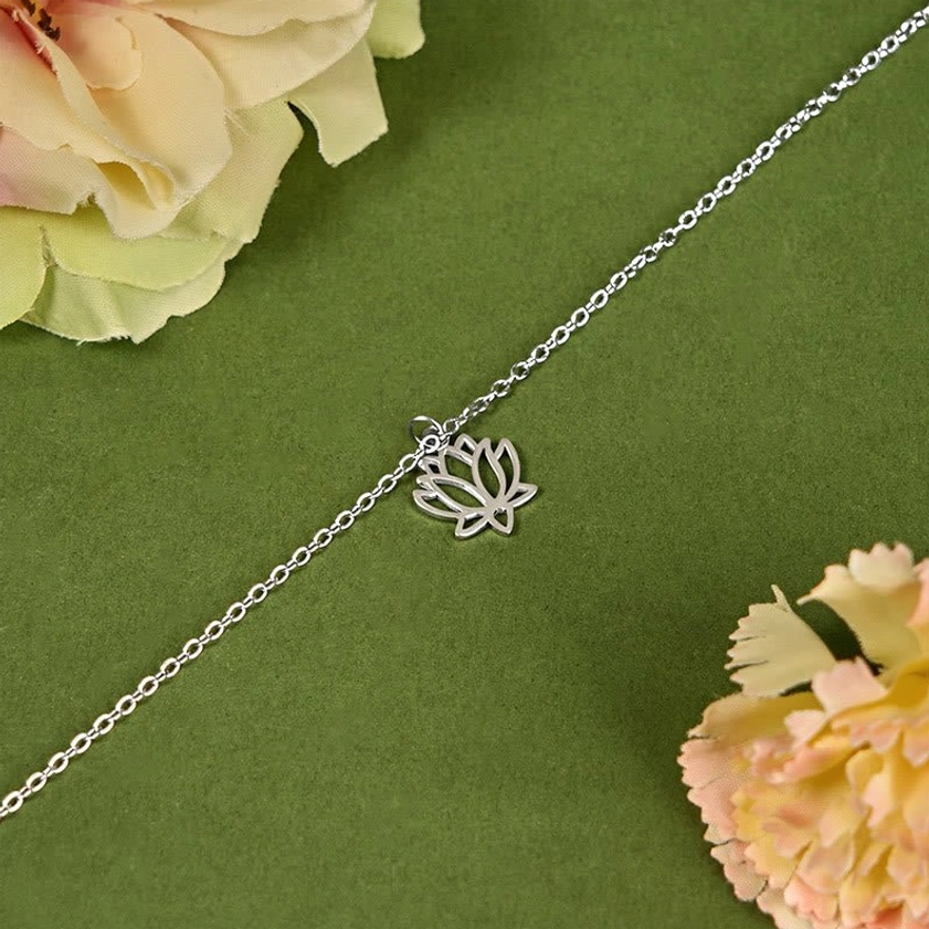 Delicate lotus pendant titanium steel charm bracelet close-up with thin silver tone chain