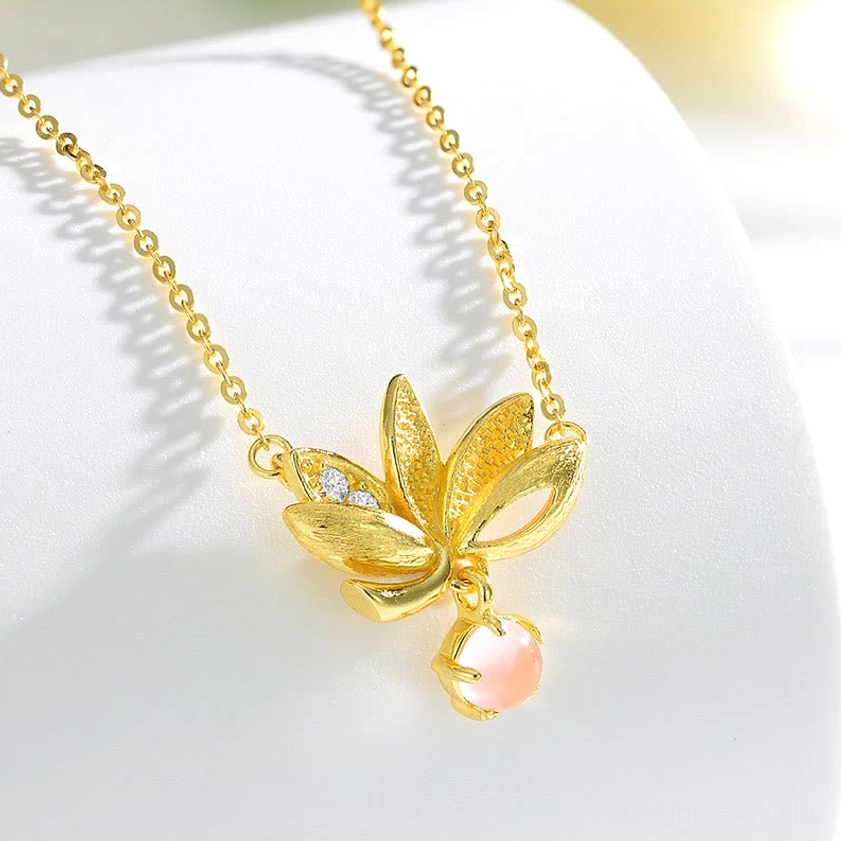 Sterling silver lotus necklace displayed on curved jewelry stand showing full pendant and polished chain profile
