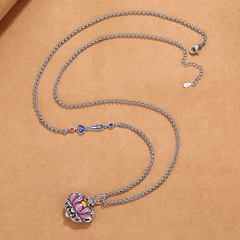 Flat lay lotus pendant necklace with silver rolo chain and small pink lotus charm, complete product view on neutral background