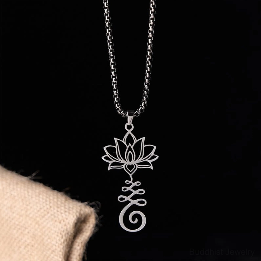 Hanging silver lotus Buddhist necklace pendant showing front view of intricate hollow carved design on beige studio background