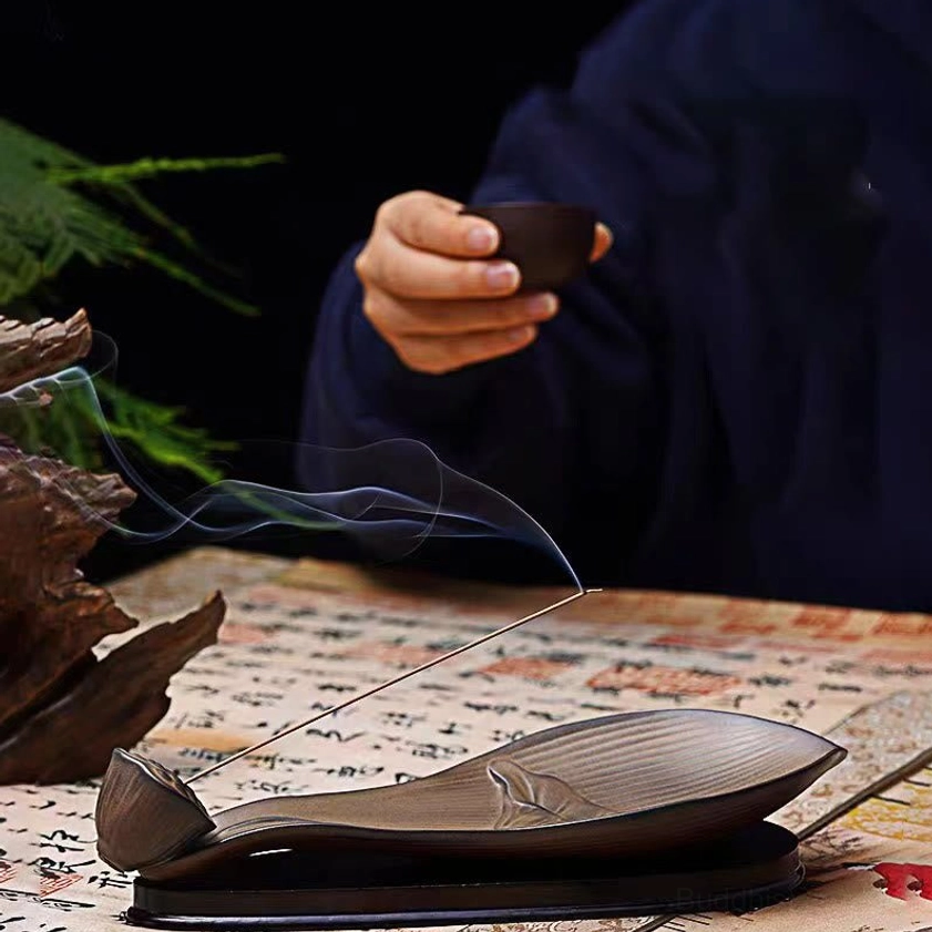 Lotus pod incense holder with drifting aromatic smoke in tea ceremony setting, brown ceramic material
