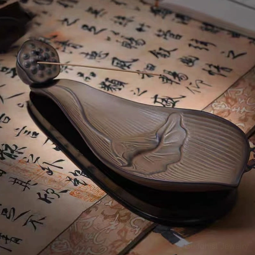Top view of lotus pod incense holder on calligraphy scroll, showing embossed lotus design and striped ceramic texture