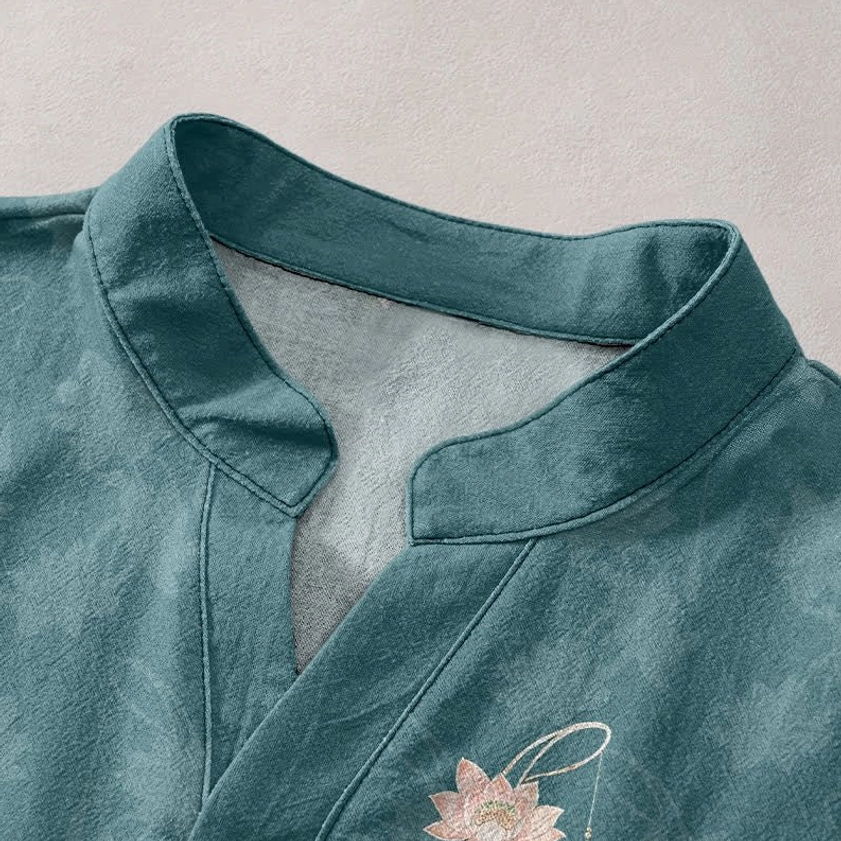 Close-up detail of teal stand collar with tiny lotus print on men's short sleeve buddhist-inspired shirt