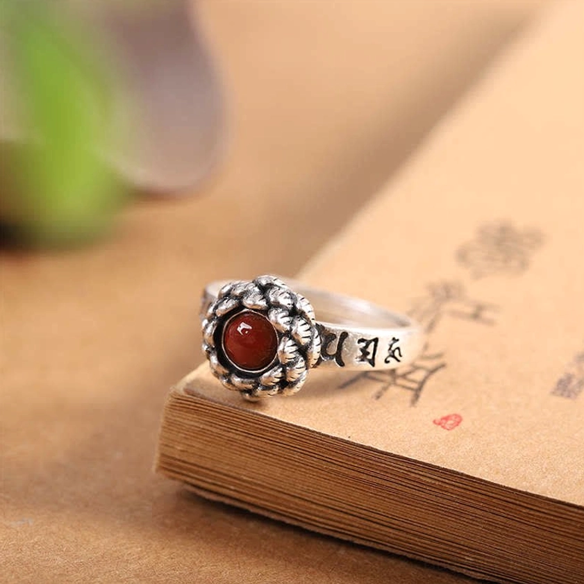 Vintage sterling silver lotus red agate ring oblique side view showing intricate lotus setting on book