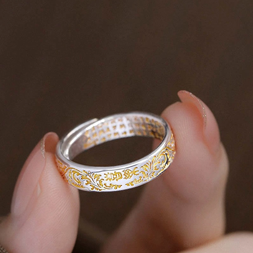 Close-up detail view of adjustable Buddhist ring showing intricate outer tang dynasty carvings and inner heart sutra engravings