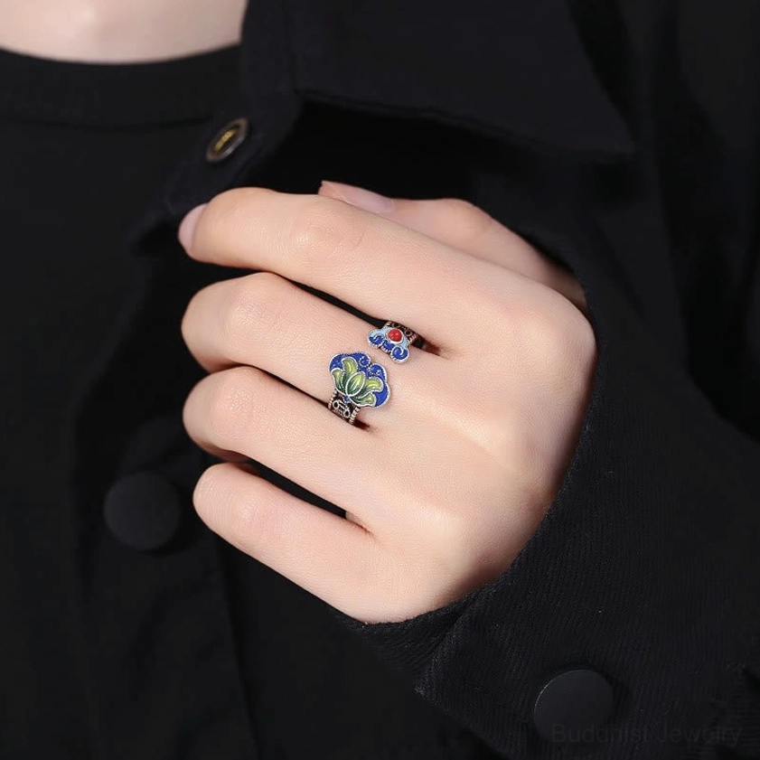 Worn on hand showing silver-toned buddhist lotus ring on middle finger with ethnic vintage aesthetic
