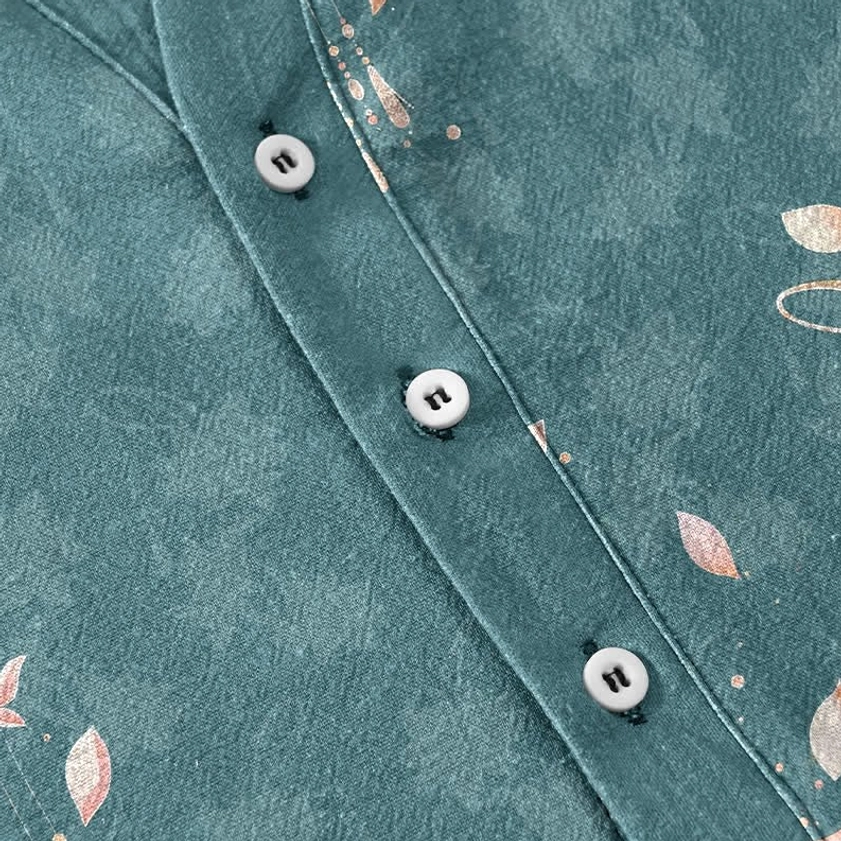 Half button placket detail with white buttons on teal lotus print cotton shirt