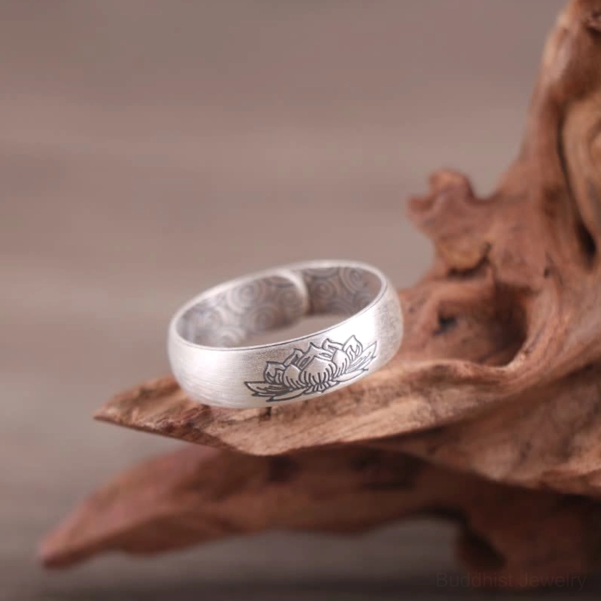 Silver lotus engraved open adjustable ring with matte finish displayed on dried lotus ornament