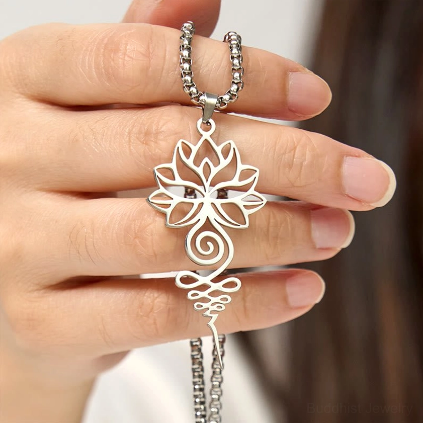 Hand-held silver lotus unalome chakra necklace with eye-level perspective showing polished stainless steel and detailed pendant design