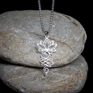 Lotus unalome chakra stainless steel Buddhist necklace pendant overhead close-up view on stone backdrop