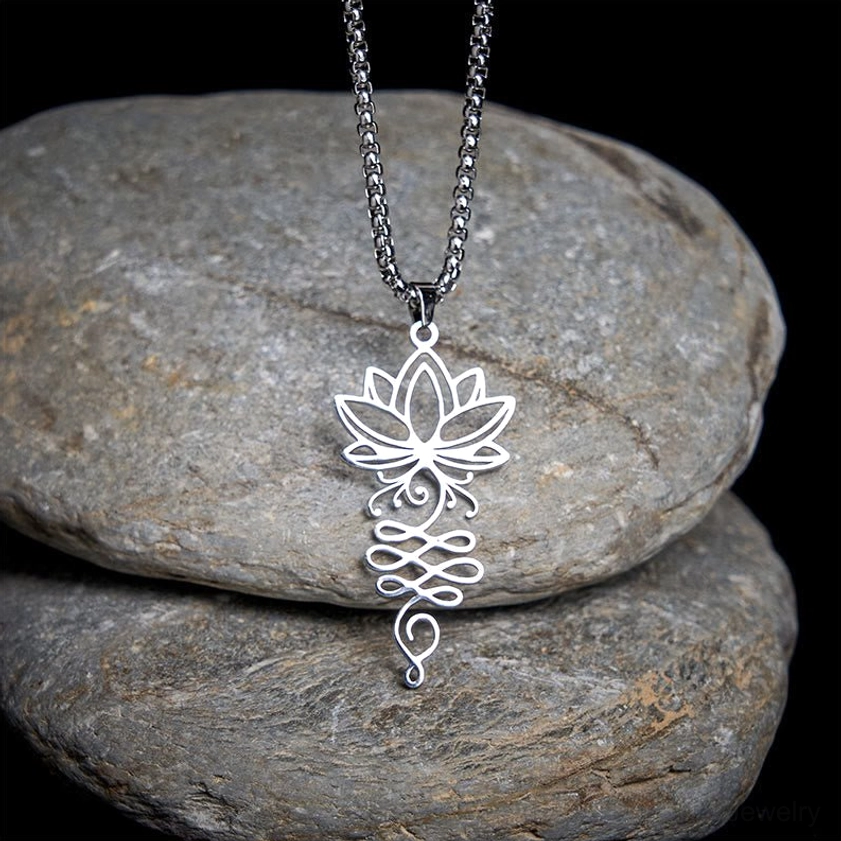 Lotus unalome chakra stainless steel Buddhist necklace pendant overhead close-up view on stone backdrop