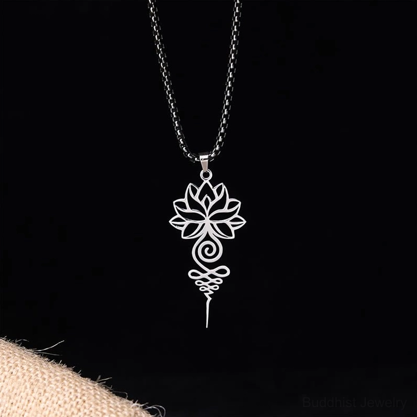 Vertical view of silver lotus unalome spiritual necklace with polished stainless steel finish and beige knit accessory backdrop