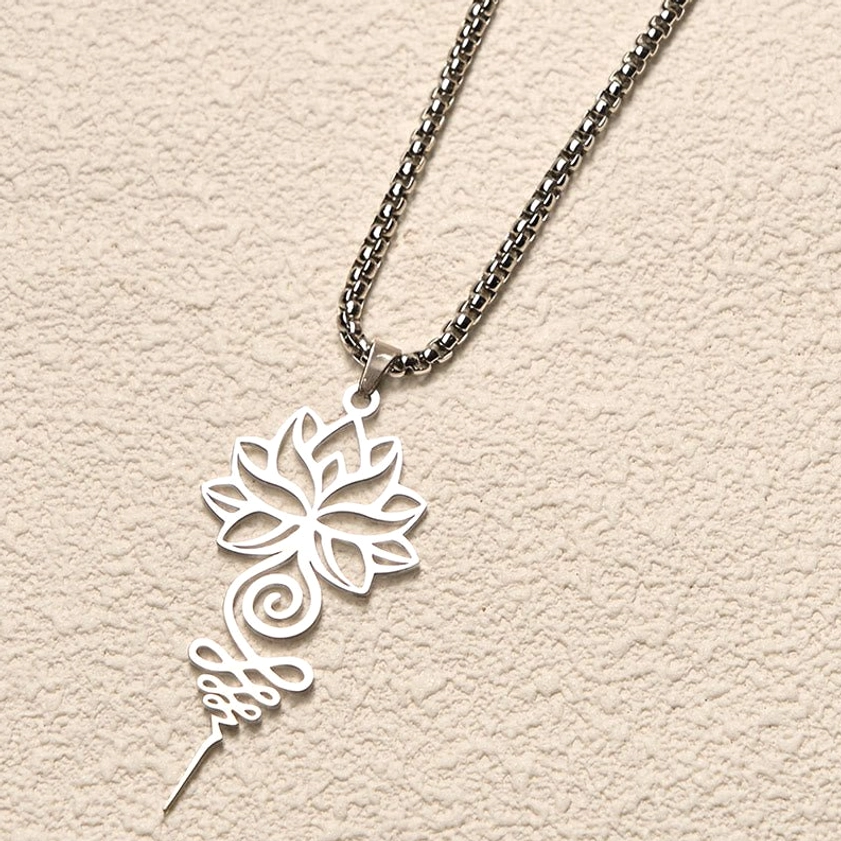 Silver lotus unalome Buddhist necklace with curb-style chain on textured beige wall, detailed filigree hollow design