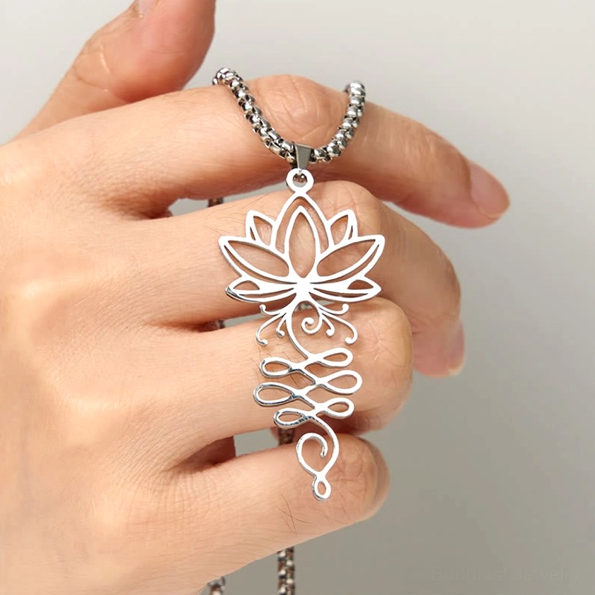 Lotus unalome necklace pendant stainless steel held in hand showing size and craftsmanship