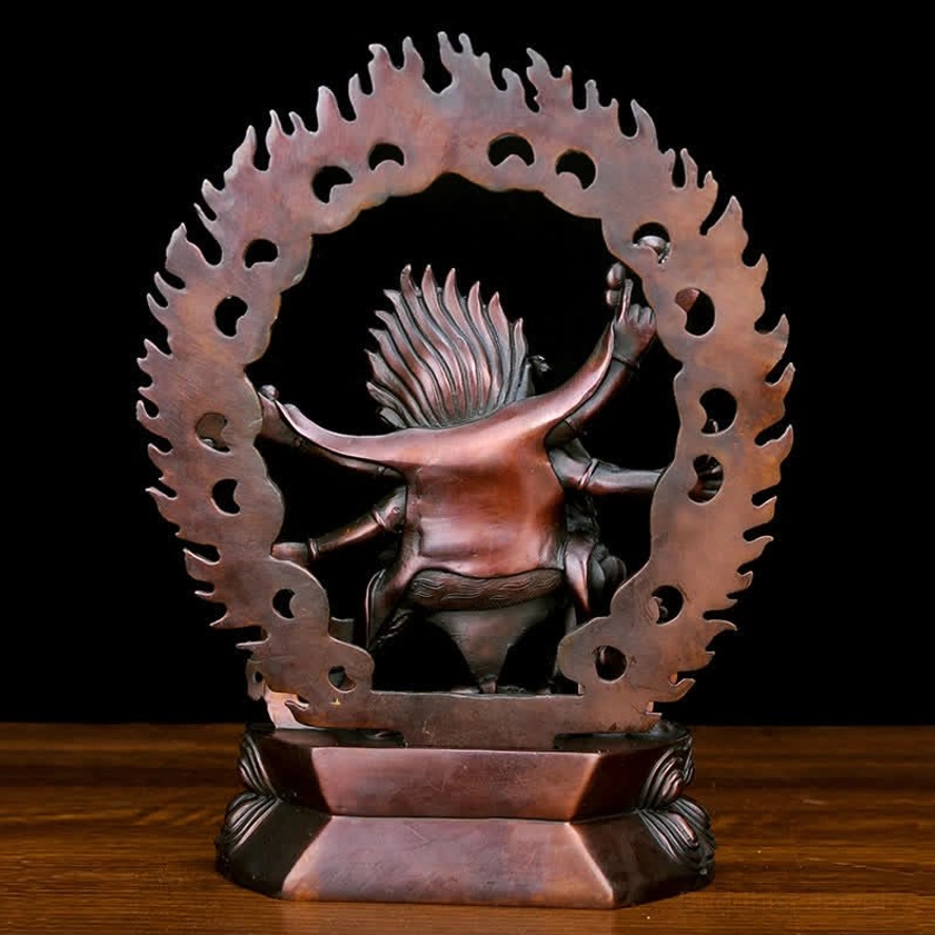 Rear angle of handcrafted Mahakala copper deity statue showing hollowed flame aureole and layered pedestal architecture