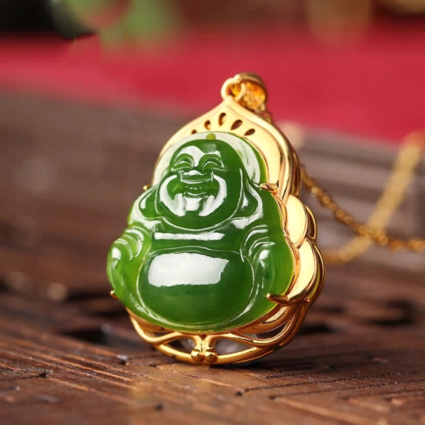 Laughing Buddha jade pendant with decorative gold metal setting, side angle view on carved wooden table