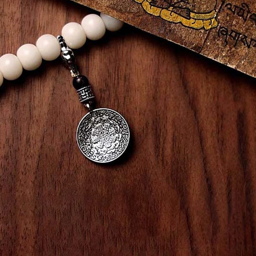 Buddhist 108 prayer mala featuring bagua silver medallion pendant with engraved design, black spacer beads, bodhi seed strand
