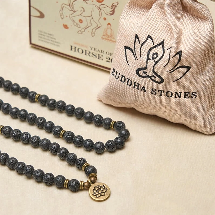 Buddhist mala sets displayed with branded linen storage bag and lotus charm beads on light beige surface