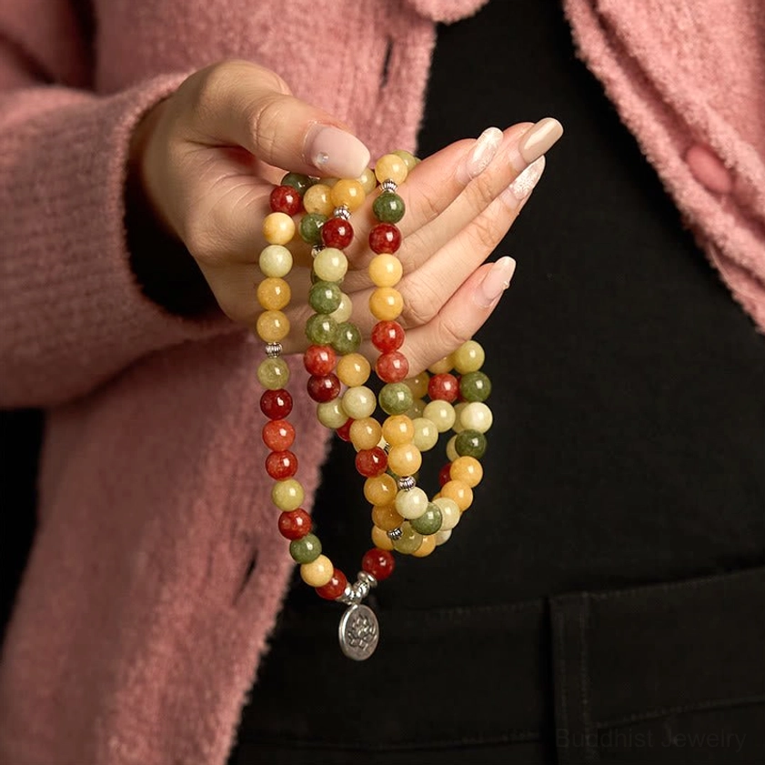 Detailed overhead close-up of mala beads showing topaz red jasper green jasper stones with metal spacer beads and lotus pendant