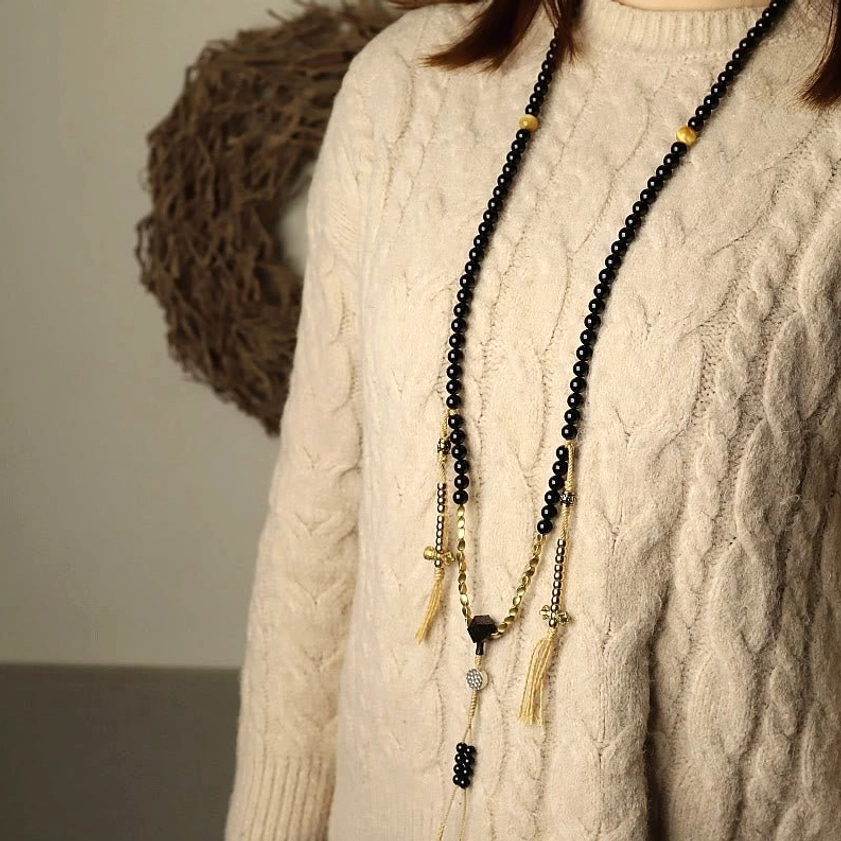 Mala beads prayer necklace worn on body showing long hanging design with protective dzi beads