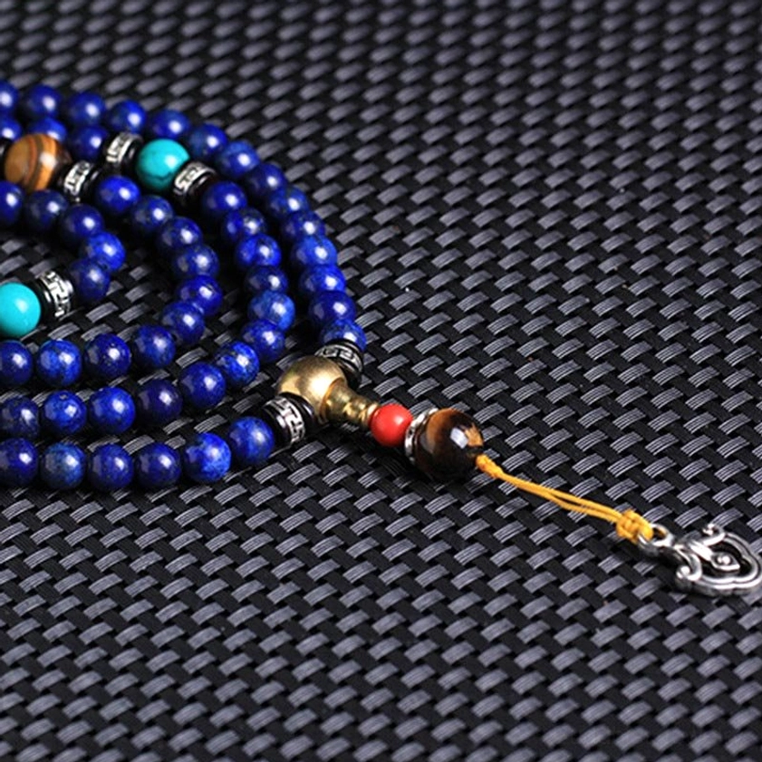 Side angle close-up of coiled lapis lazuli mala beads with turquoise inlays silver spacers and tiger eye stone on dark background