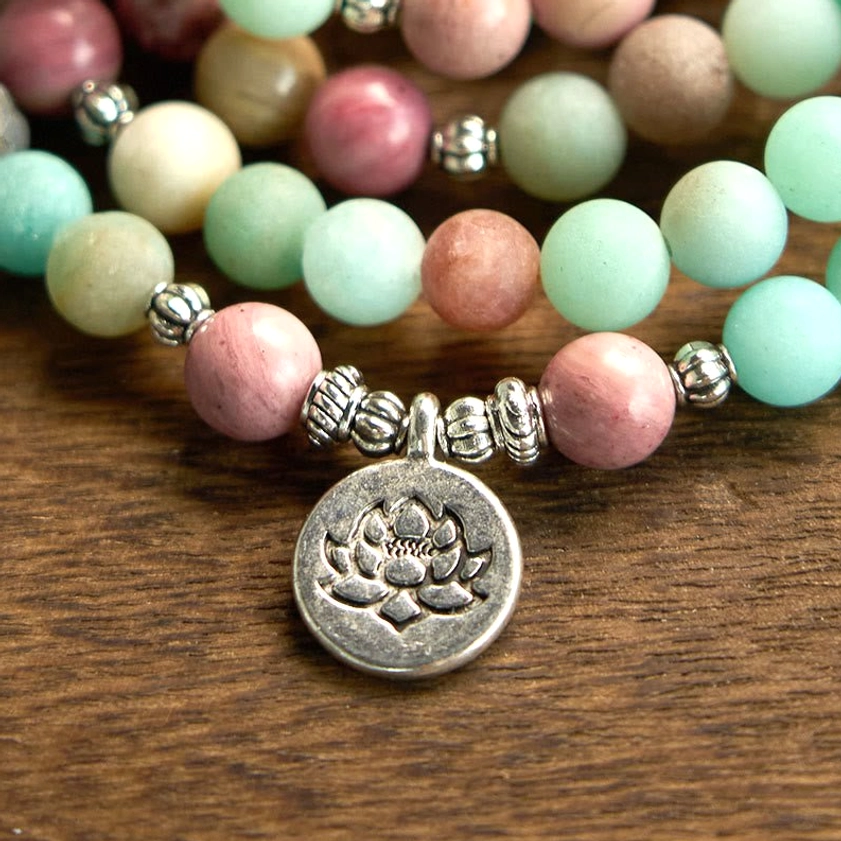 Macro close-up detail of 108 mala bracelet showing mixed stone beads, silver spacers, and engraved lotus silver medallion
