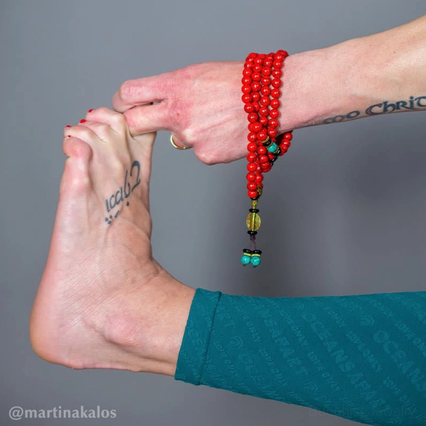 Red turquoise mala bracelet worn on wrist with bronze hardware and turquoise charm detail