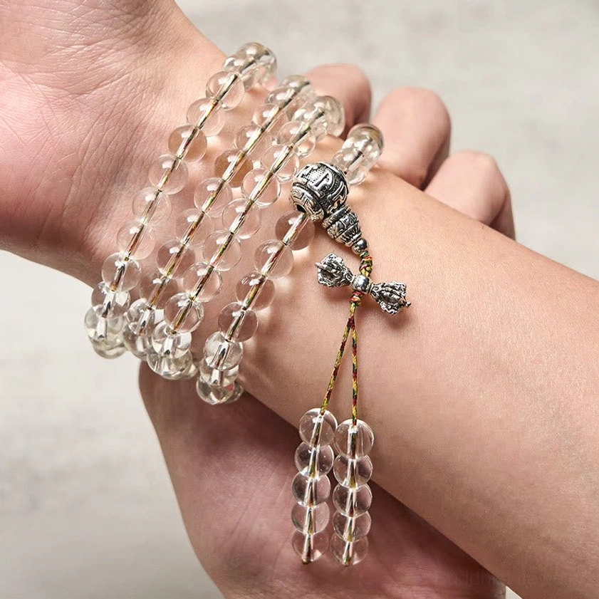Crystal mala bracelet worn on wrist - close-up view showing silver vajra charm pendant and multi-color accent beads on human hand