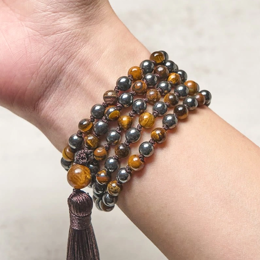 Wrapped mala beads worn on wrist multiple times close-up view with dark tassel