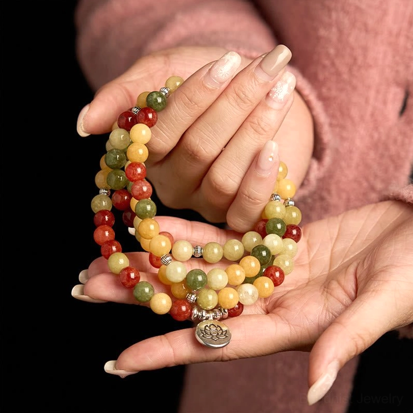 Stacked mala bead bracelets displayed in two open palms showing lotus silver charm and mixed natural gemstone beads