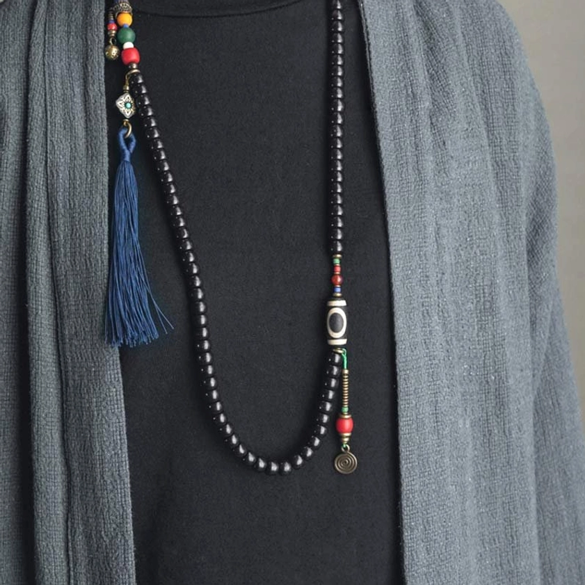 Long mala prayer necklace with 108 ebony wood beads, dzi bead, and navy tassel - front wear view