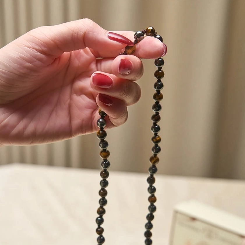 Hand held 108 bead mala prayer necklace natural light showing bead texture and hang