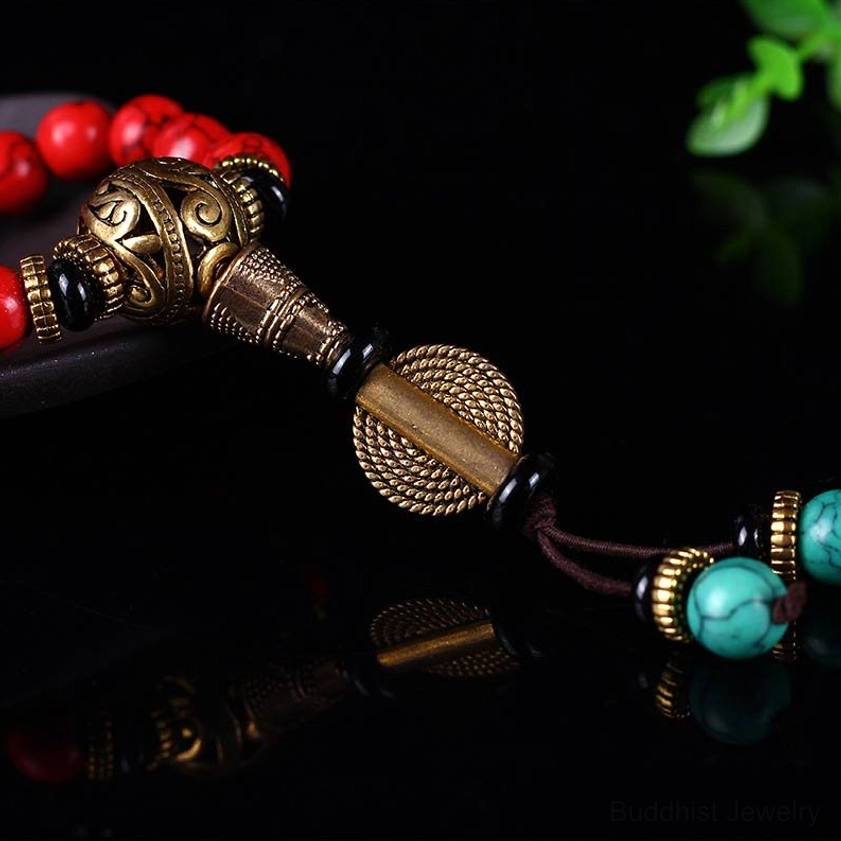 Handcrafted mala pendant hardware macro close-up showing carved bronze and turquoise bead accents