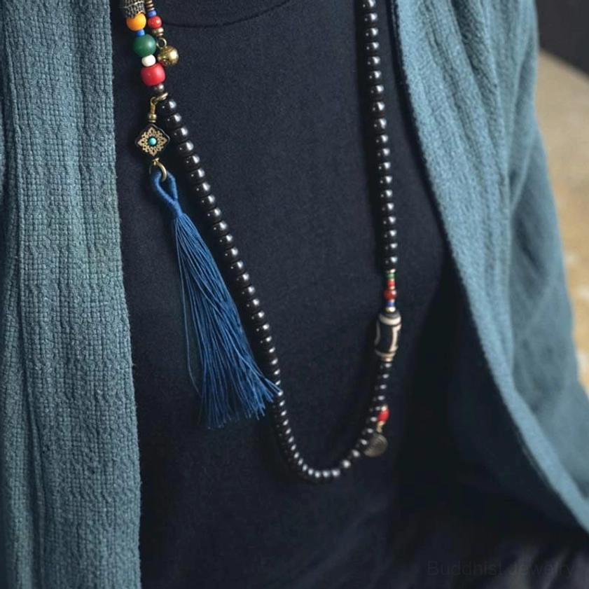 Mala necklace layered over outfit with black ebony beads and colorful metal trinkets