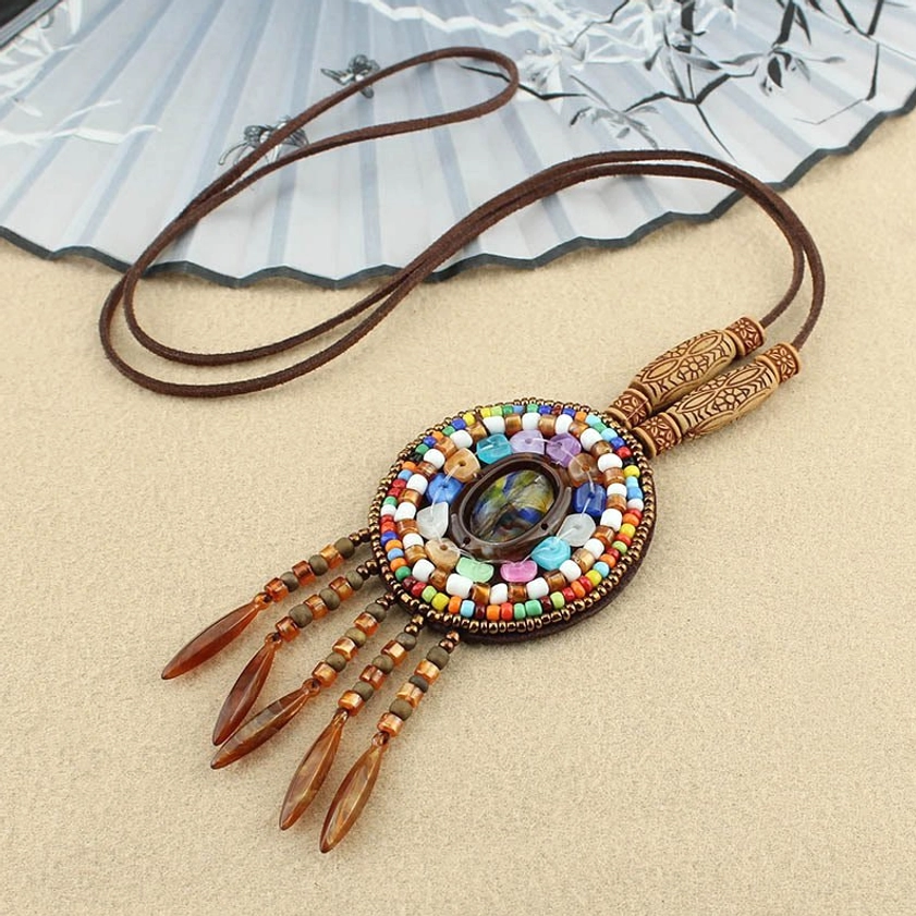 Single round mandala beaded pendant necklace with colorful mosaic inlay and brown leather cord from 3/4 view