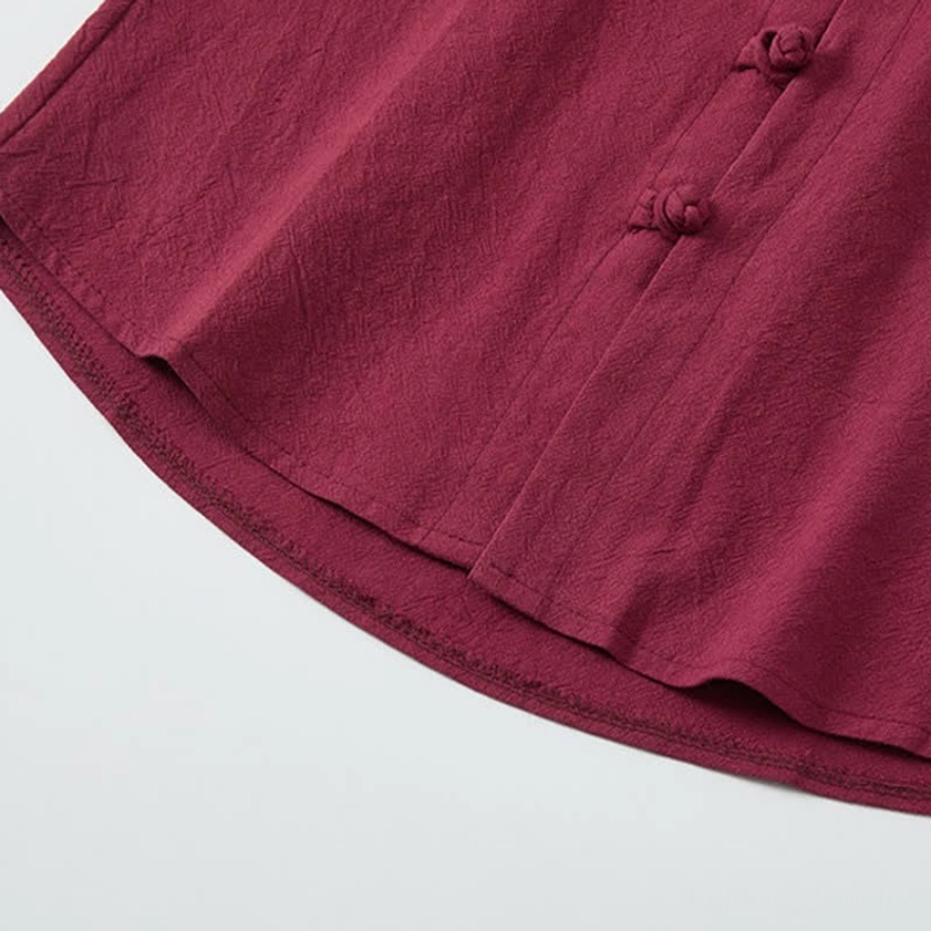 Mandarin collar and frog button detail on burgundy meditation shirt hem, textured woven fabric