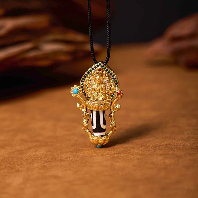 Manjusri Bodhisattva statue with hand-painted Dzi Bead in gilded copper frame and turquoise inlay, three-quarter angle on wooden background