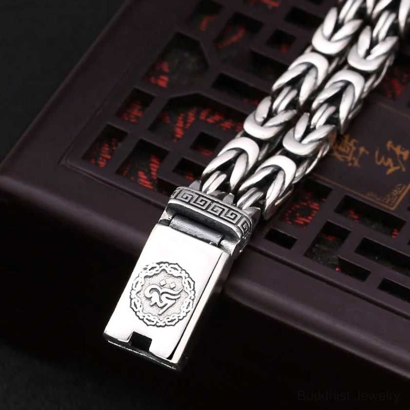 Close-up detail of Om Mani Padme Hum bracelet clasp showing auspicious embossed pattern and woven chain link
