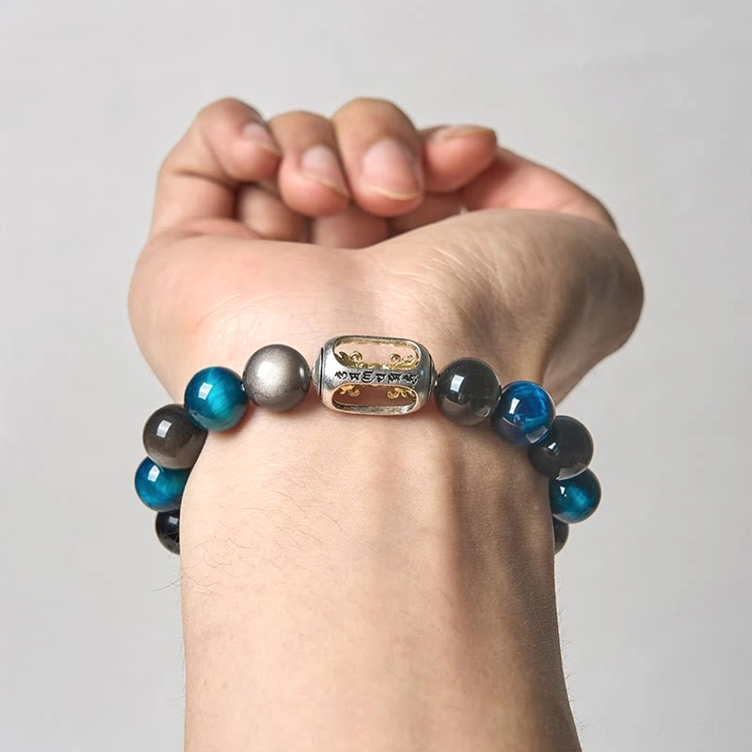 Worn on adult wrist close-up view showing Silver Sheen Obsidian and Blue Tiger Eye Buddhist bracelet in real wear