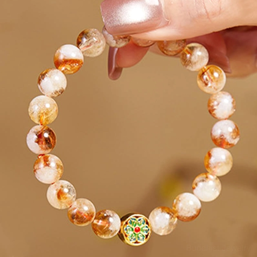 Close-up of sterling silver enamel Om Mani Padme Hum charm on citrine beaded bracelet