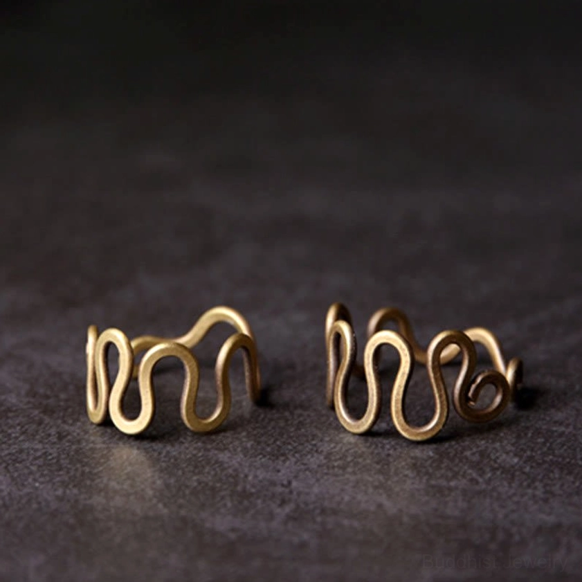 Pair of matching curved brass wave rings for prosperity showing identical antique golden bronze wavy bands