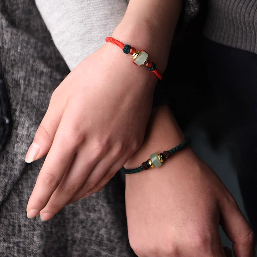 Couple matching green aventurine Buddhist bracelets worn on two wrists with unified charm design
