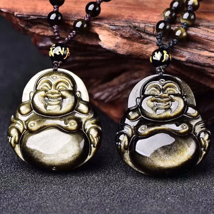 Pair of matching gold sheen obsidian Buddha pendants with beaded necklaces displayed on wooden background flat lay